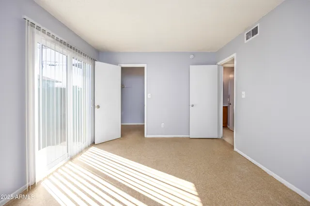 a view of a livingroom with wooden floor and a bathroom