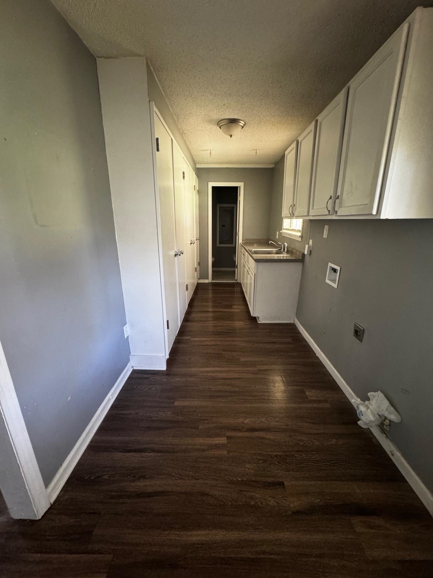 1112 Shoaf Road Covington, TN 38019 - Photo 12 of 17 Hallway featuring a textured ceiling and dark wood-type flooring