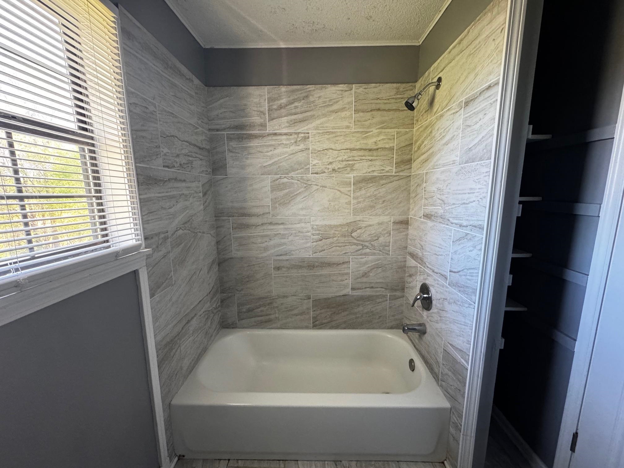 1112 Shoaf Road Covington, TN 38019 - Photo 16 of 17 Bathroom with bathing tub / shower combination, crown molding, and a textured ceiling