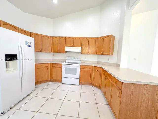 a kitchen with a cabinets and white appliances