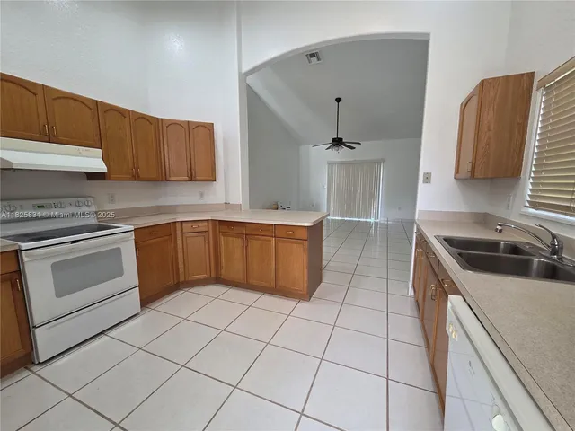 a kitchen with a sink a stove and cabinets