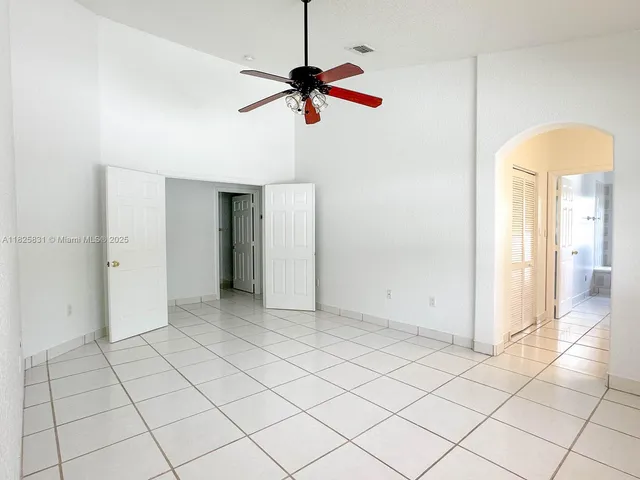 a view of a room with a chandelier fan and windows