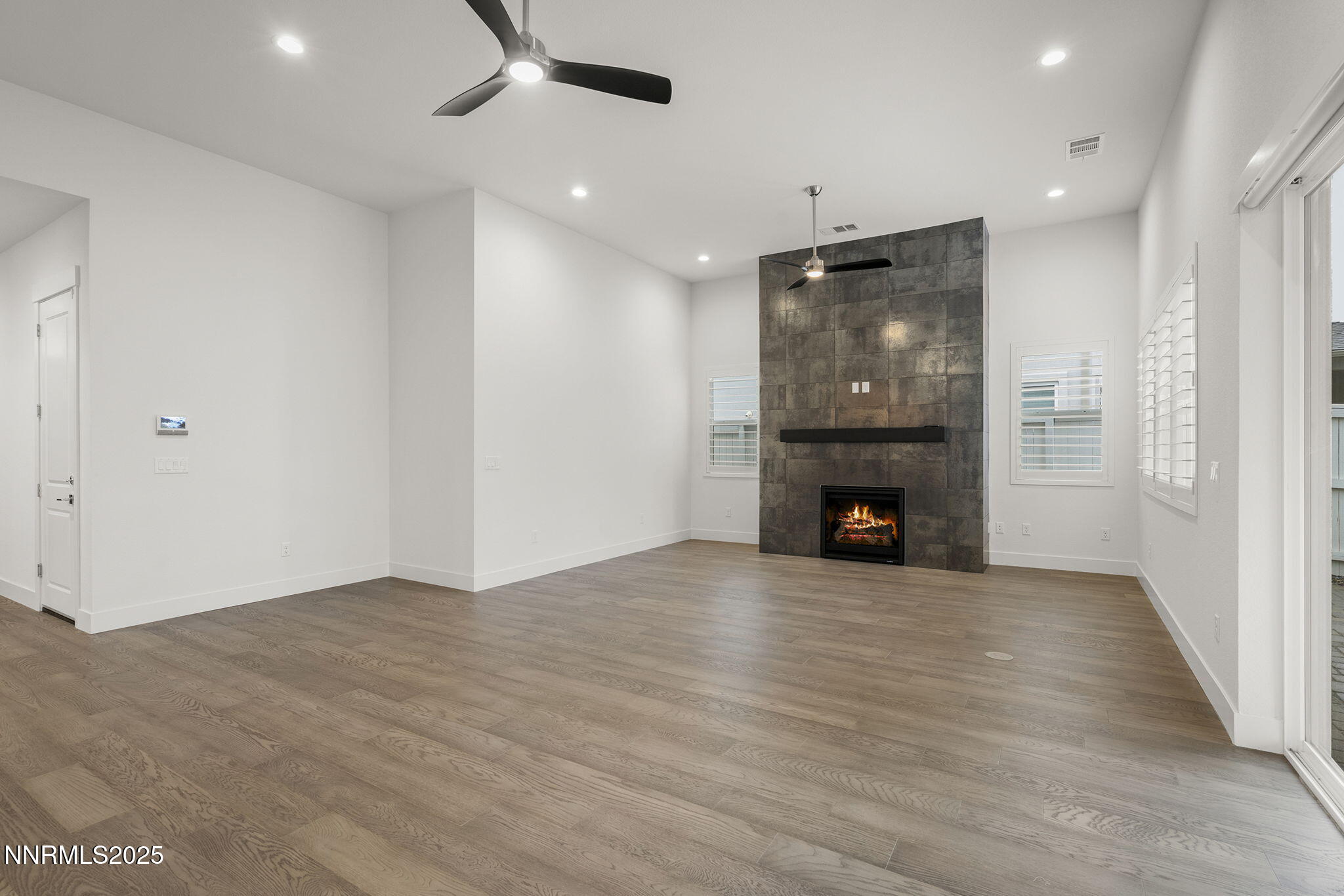 5513 Western Rider Trail Reno, NV 89511 - Photo 5 of 36 an empty room with wooden floor fireplace and windows