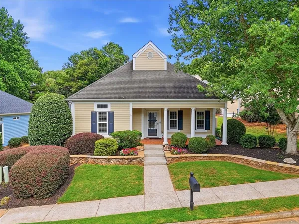 a front view of a house with a yard and potted plants