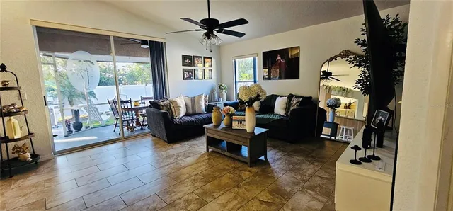 a living room with furniture large window and wooden floor