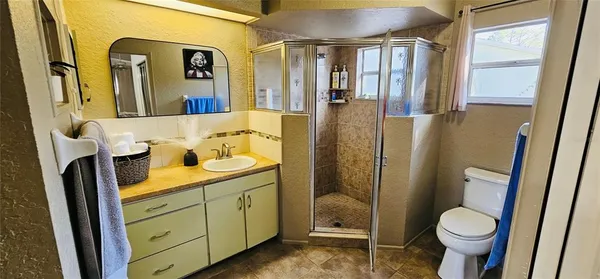 a bathroom with a granite countertop sink toilet and shower