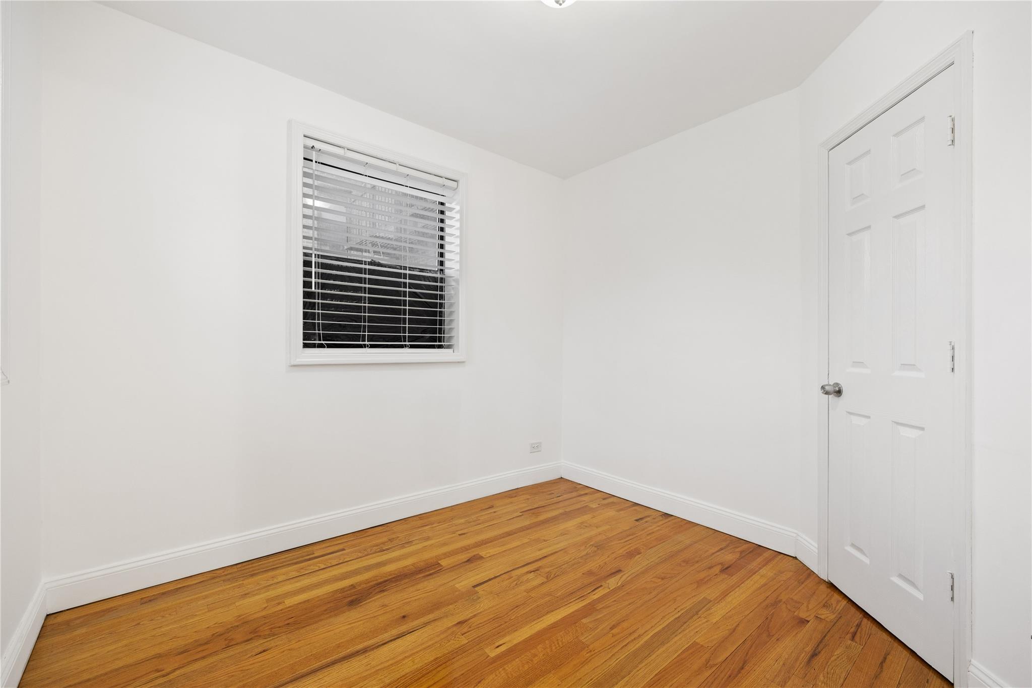 140-10 84th Drive, Unit 1B Queens, NY 11435 - Photo 12 of 32 Unfurnished room with hardwood / wood-style floors