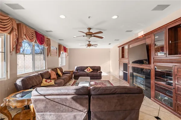 a living room with furniture a flat screen tv and a window