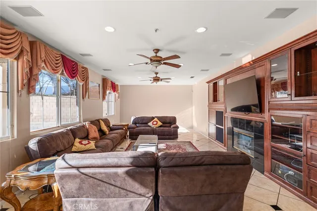 a living room with furniture a flat screen tv and a window