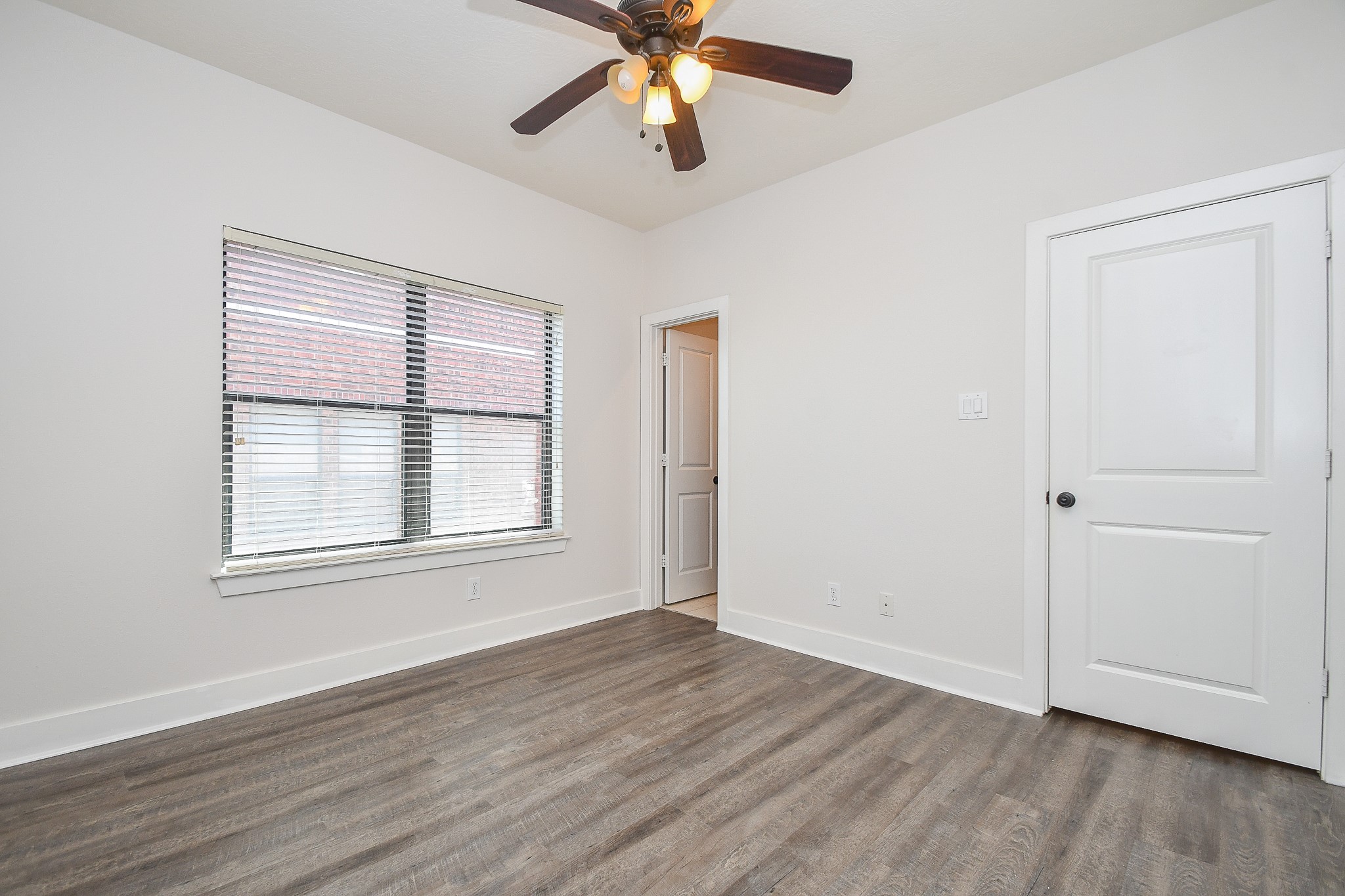 2422 Navigation Boulevard, Unit A Houston, TX 77003 - Photo 23 of 32 an empty room with wooden floor chandelier fan and windows