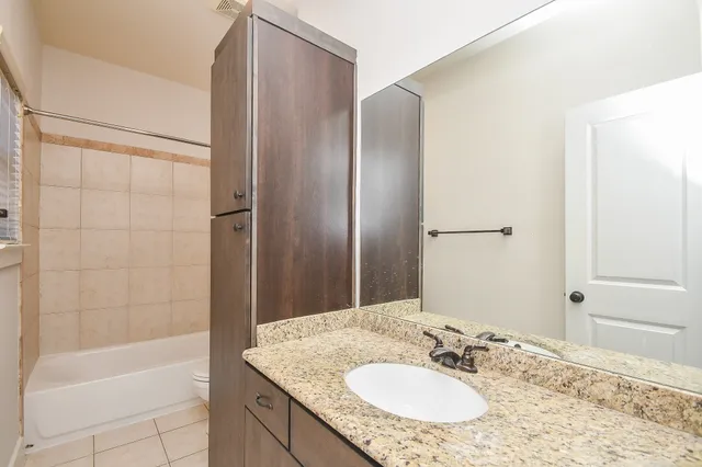 a bathroom with a granite countertop bathtub shower sink and a mirror