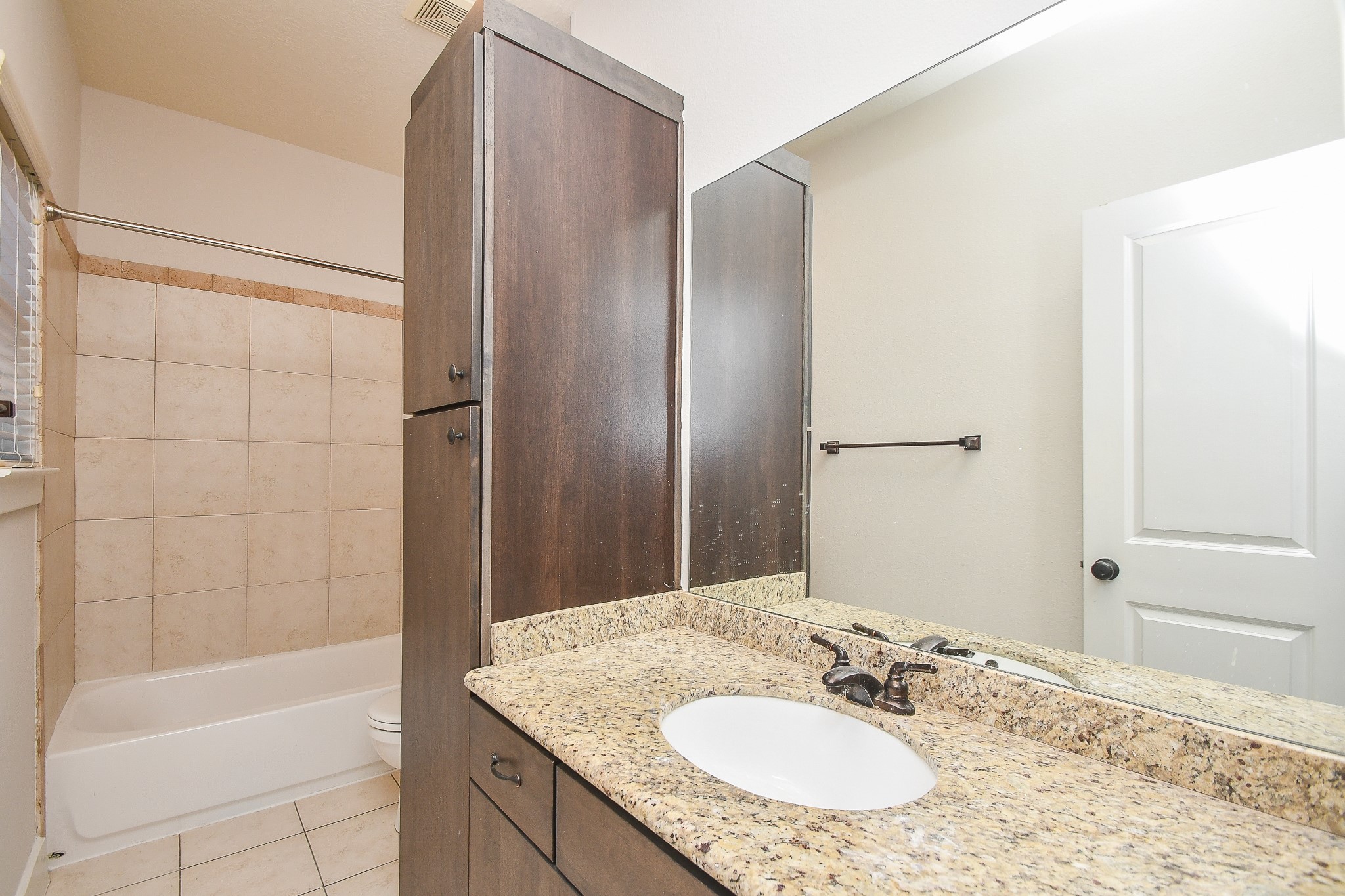 2422 Navigation Boulevard, Unit A Houston, TX 77003 - Photo 25 of 32 a bathroom with a granite countertop bathtub shower sink and a mirror