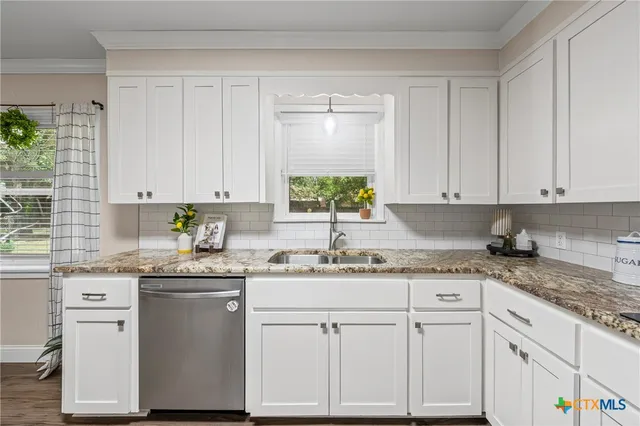 a kitchen with granite countertop white cabinets white appliances and sink