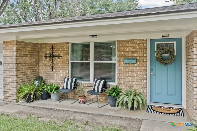 a front view of a house with outdoor seating and a potted plant