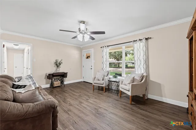 a living room with furniture and a wooden floor