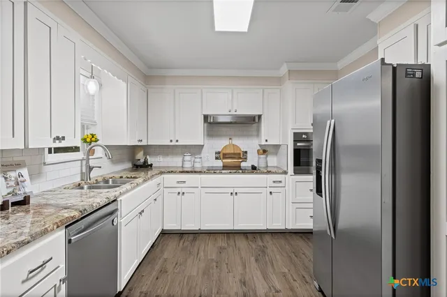 a kitchen with white cabinets and stainless steel appliances