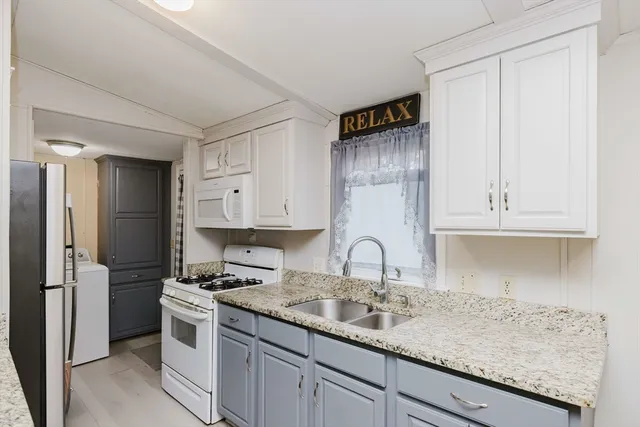 a kitchen with granite countertop a sink stainless steel appliances and cabinets