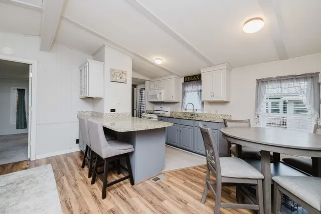a kitchen with a table chairs sink and cabinets