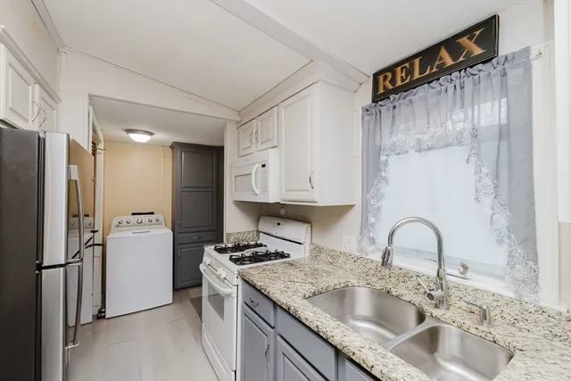 a kitchen with granite countertop a sink stainless steel appliances and cabinets