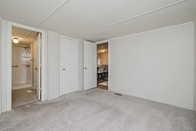 an empty room with closet and a bathroom