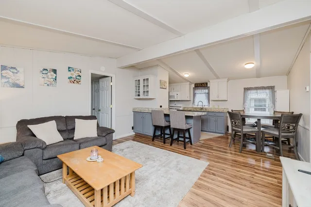 a living room with furniture a dining table and a refrigerator