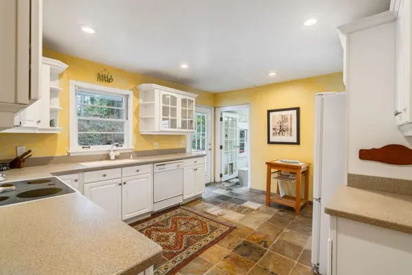 a kitchen with a refrigerator a stove top oven a sink and cabinets