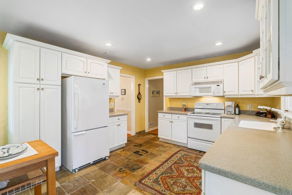 2368 Peeler Road Dunwoody, GA 30338 - Photo 12 of 47 a kitchen with a refrigerator a stove top oven a sink and cabinets