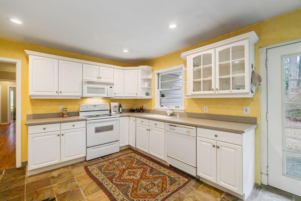 2368 Peeler Road Dunwoody, GA 30338 - Photo 15 of 47 a kitchen with granite countertop white cabinets and white appliances