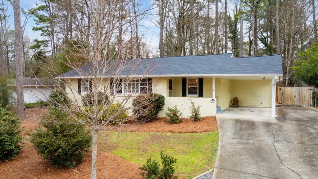 2368 Peeler Road Dunwoody, GA 30338 - Photo 2 of 47 a front view of a house with a garden and trees