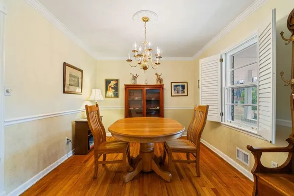 a dining room with furniture a chandelier and wooden floor