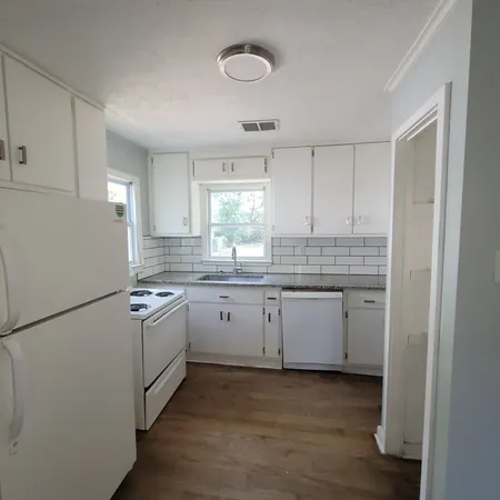 a kitchen with a sink cabinets stainless steel appliances and a window