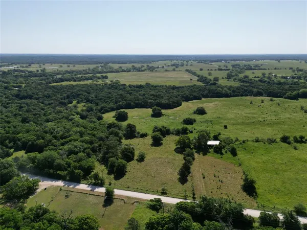 an aerial view of a houses with outdoor space and trees
