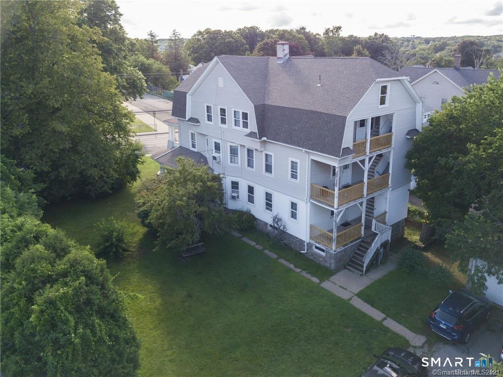 393 Highland Avenue, Unit 2 Waterbury, CT 06708 - Photo 9 of 10 a view of a large building with a big yard plants and large trees
