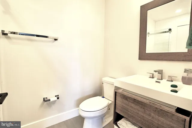 a bathroom with a sink toilet and a mirror