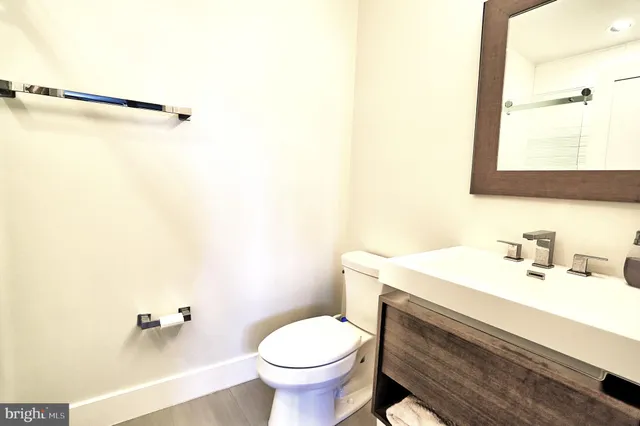 a bathroom with a sink toilet and mirror