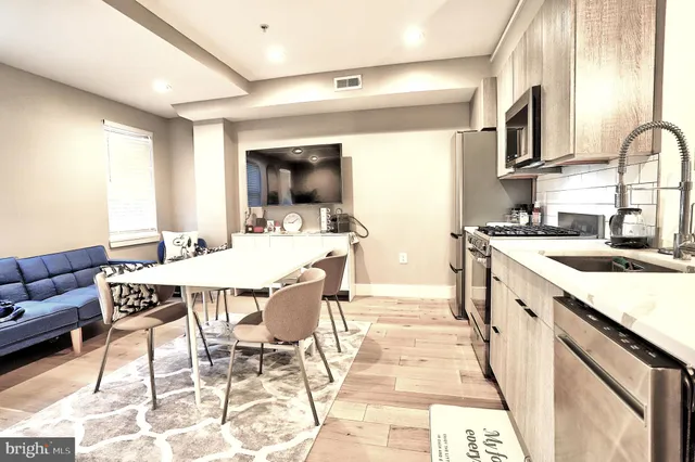 a kitchen with a stove a sink a dining table and chairs