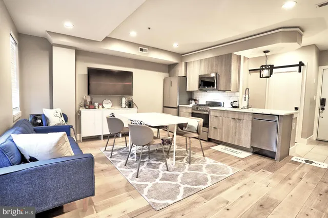 a living room with lots of furniture and kitchen view