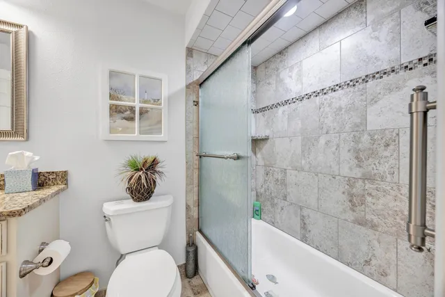 a white toilet sitting next to a bath tub shower