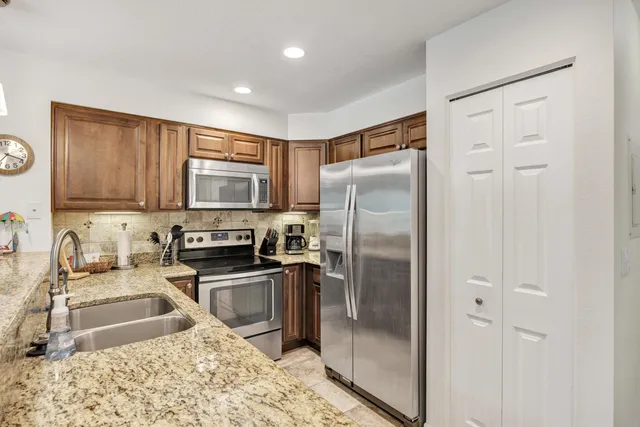 a kitchen with granite countertop a refrigerator and a sink