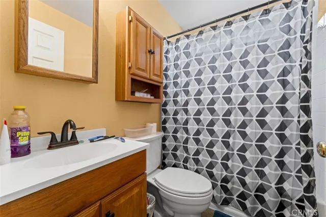 a bathroom with a sink a toilet and a shower curtain