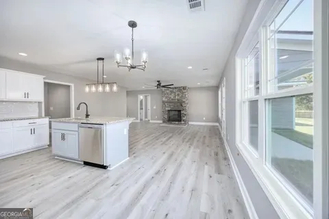 a large kitchen with cabinets wooden floor and stainless steel appliances