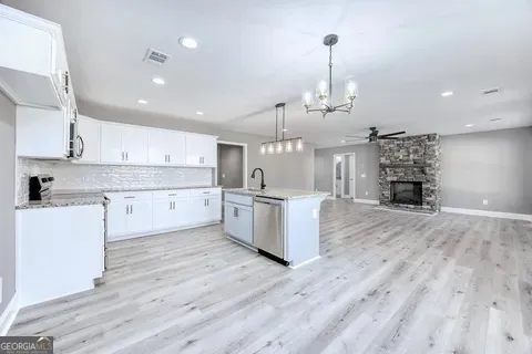 a large kitchen with stainless steel appliances granite countertop a lot of counter space and wooden floors