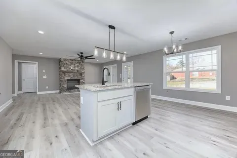 a kitchen with stainless steel appliances granite countertop a stove and a wooden floors
