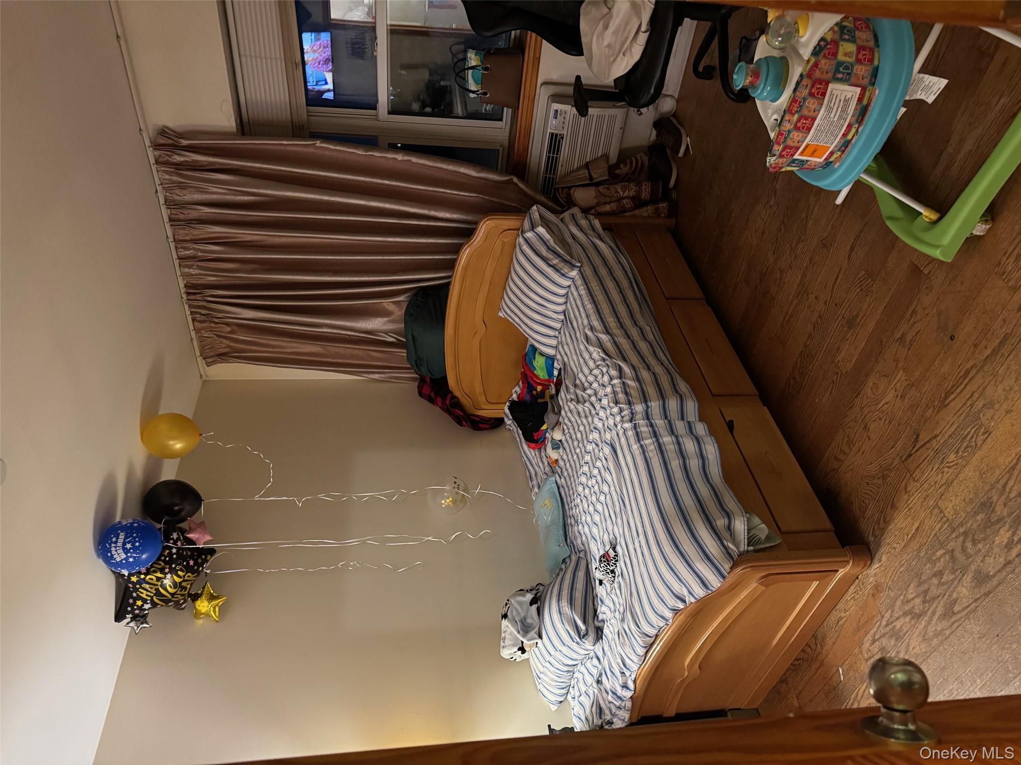 108-15 37th Drive, Unit 4B Queens, NY 11368 - Photo 4 of 10 a bedroom with a bed and a chandelier