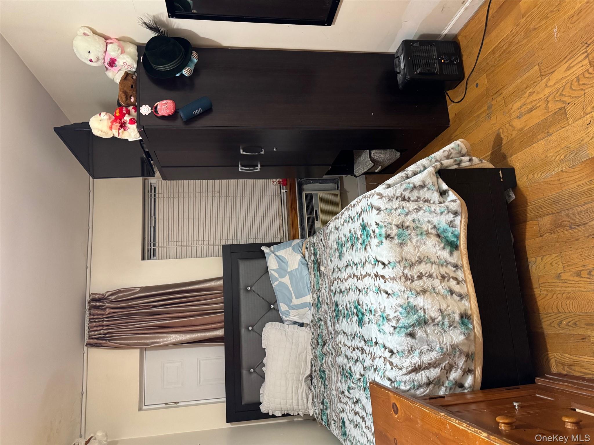 108-15 37th Drive, Unit 4B Queens, NY 11368 - Photo 5 of 10 a bedroom with a bed and a mirror