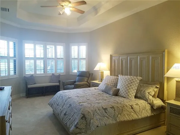 a spacious bedroom with a bed and a chandelier