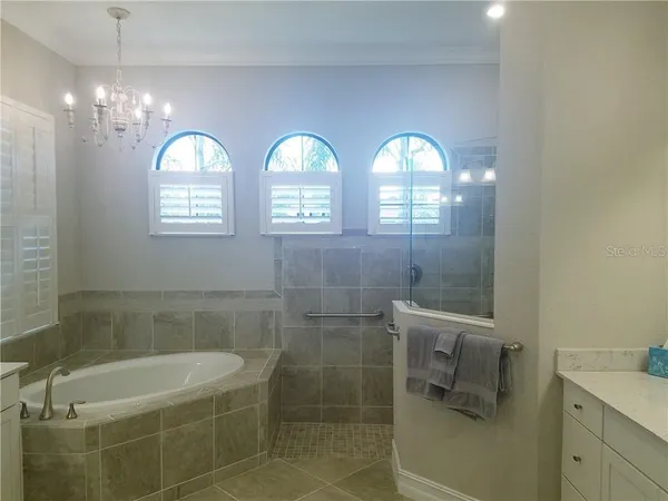 a bathroom with a mirror a bathtub and shower