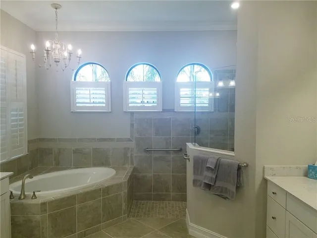 a bathroom with a mirror a bathtub and shower