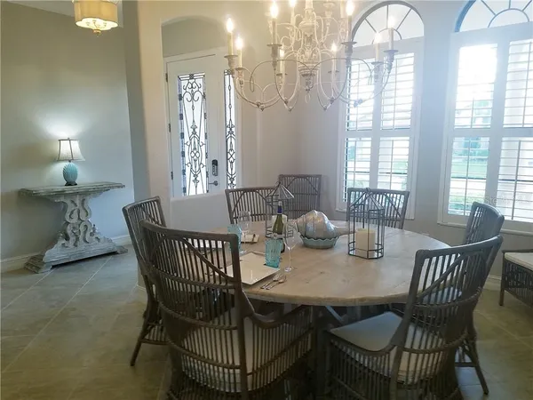 a view of a dining room with furniture and chandelier