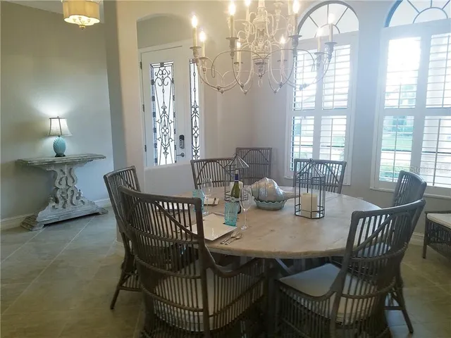 a view of a dining room with furniture and chandelier
